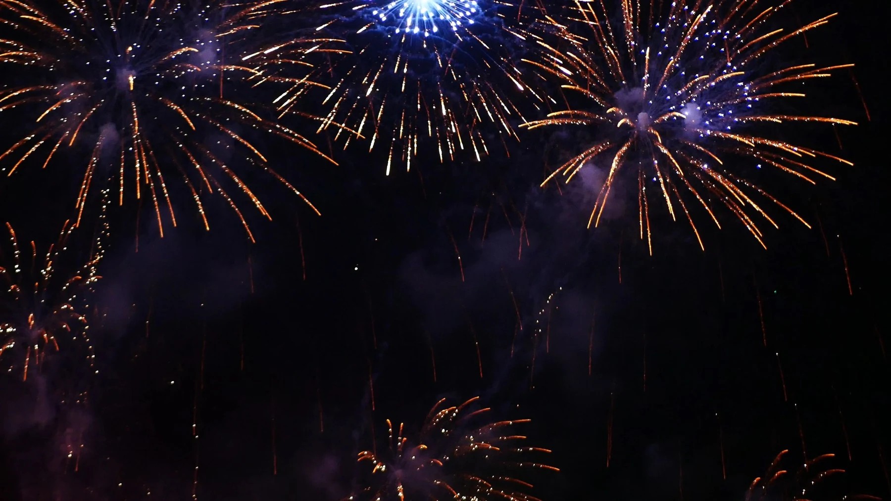 Golden fireworks in the night sky above a celebration