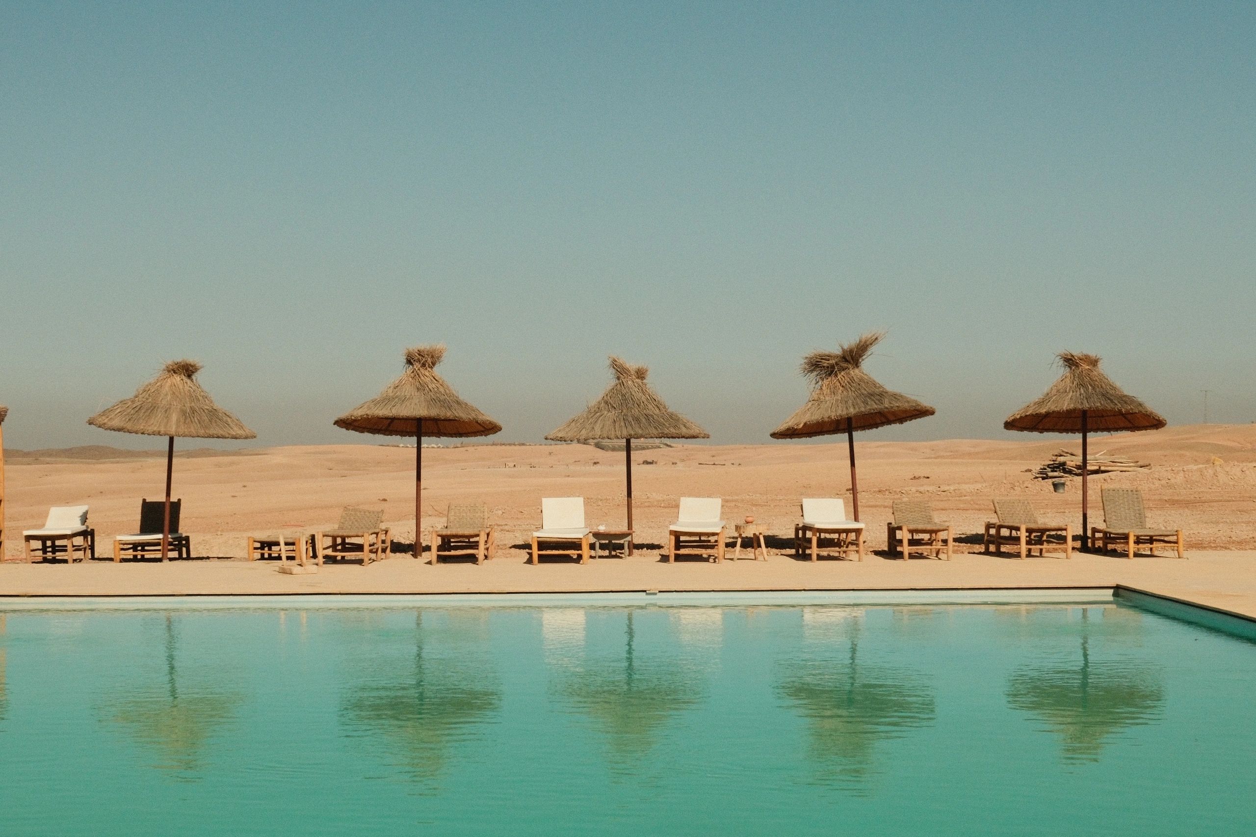 Luxury resort pool with loungers and umbrellas in a scenic setting